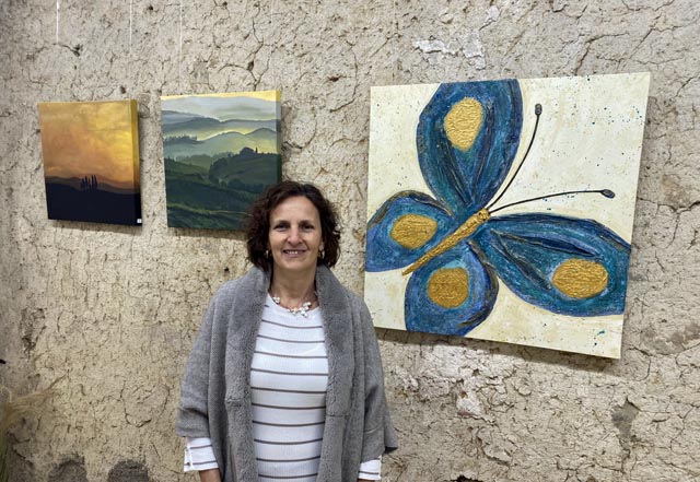 Manuela Widmer mit drei ihrer Bilder. Der Schmetterling entstand in ihrem Malkurs im Piemont und wurde zum Sinnbild für den Start ihrer Malkarriere. Foto: Sonja Fasler